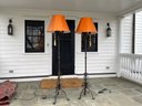 A Pair Of Wrought Iron Floor Lamps With Orange Shades