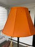 A Pair Of Wrought Iron Floor Lamps With Orange Shades