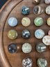 AN ANTIQUE MARBLE BOARD WITH LABELED STONE MARBLES