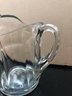 Vintage Heavy Pressed Glass Pitcher With Ribbon Edge Design, Starburst Bottom And Curved Decorative Ice Lip.