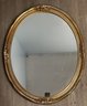 A Gilt Oval Mirror By Carolina Mirror Co.