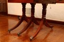 Antique Mahogany Drop Leaf Table With Three  Turned Pedestal Legs On Brass Casters