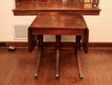 Antique Mahogany Drop Leaf Table With Three  Turned Pedestal Legs On Brass Casters