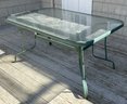 An Outdoor Glass Top Aluminum Frame Patio Dining Table.