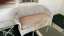 An Antique Wicker Loveseat With Two Metal And Glass Side Tables.