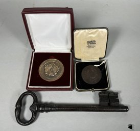 TWO BRONZE MEDALS AND A LARGE IRON KEY