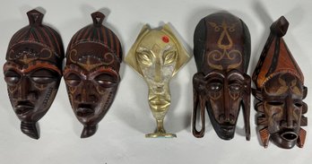 FOUR CARVED KENYAN TRIBAL MASKS AND A CAST BRASS SCULPTURE