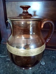 Amber Glass Lidded Pitcher With Gold Colored Accents And Lovely Decorative Handle