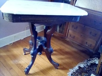 Splendid Antique Table With Marble Top, Carved Wood Features And Caster Wheels