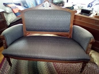 Victorian Settee With Decorative Wood Carving And Fabric Plus Caster Wheels