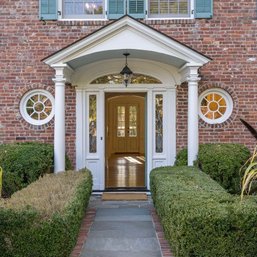 A Pair Of Round Windows Flanking Front Entry