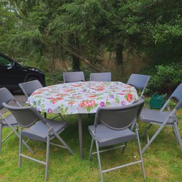 Outdoor Collapsible Round Table With Eight Chairs And Floral Tablecoth