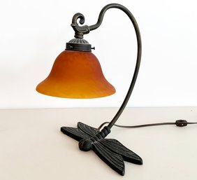 A Cast Iron Firefly Form Desk Lamp With Amber Shade