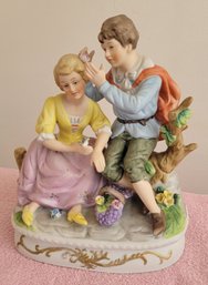 Vintage Bisque Figure Depicting A Seated Boy And Gil Catching Butterflies