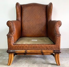 A Plantation Style Wing Back Chair In Woven Cane With Faux Bamboo Base