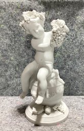 French Bisque Figure Of A Child Bacchant Seated On A Wine Cask Holding Grape Cluster