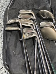 Group Of Various Golf Clubs And A Travel Bag