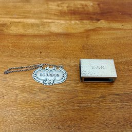 A Sterling Silver Match Box Cover And A Hanging Bourbon Bottle Label