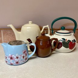 3 Tea Pots And Tea Kettle With Apples Pictured