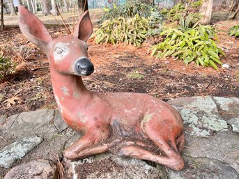 A Vintage Paint Decorated Reclining  Fawn Outdoor Cement Statuary