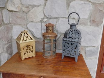 A Trio Of Hanging Candle Lanterns In Different Finishes