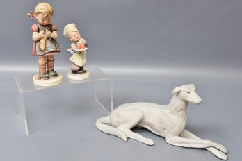 Dog Figurine And Pair Of Goebel Hummel Figurines 'A Stitch In Time' And 'Baker'