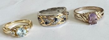 THREE RINGS TWO GOLD TONE ONE TWO TONE PINK STONE, BLUE/ WHITE STONE AND AQUA/WHITE STONE