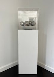 An Art Display Stand With Stainless Steel Balls - Acrylic Top