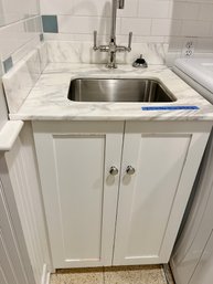 A Marble Top Kohler Hardware And Stainless Steel Sink With Wood Base - Laundry Room