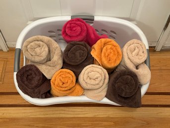 A Standard Plastic Laundry Basket With An Assortment Of Bath Towels