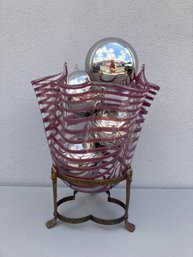 A Wavy Glass Vase Filled With Silver Balls