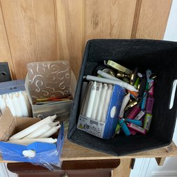 A Lidded Felt Box With Assorted Candles And Lighters