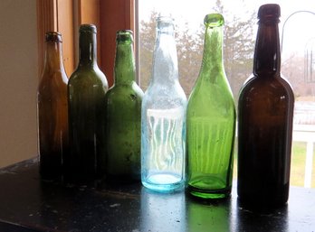 A Grouping Of  Antiqued Colored Mold Blown Beer And Ale Bottles