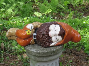 A Ceramic Garden Gnome Sleeping On His Side