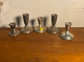 FIVE WEIGHTED STERLING SILVER CANDLESTICKS