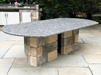 A Large Granite Slab Outdoor Table Top And Built In Stone Base