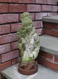 A Concrete Statue Of A Japanese Geisha Girl With Flowers