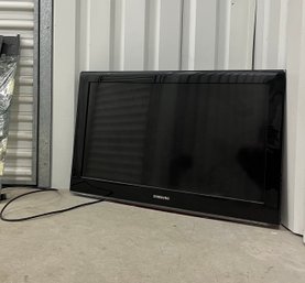 A Samsung 32 Inch Flat Screen TV With Wall Rack