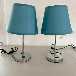 A Pair Of Chrome Desk Lamps With Blue Shades