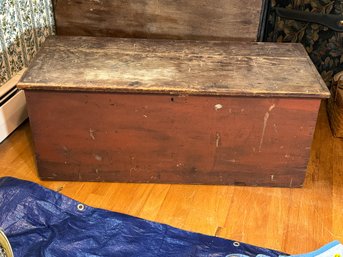 AN ANTIQUE BLANKET BOX IN OLD RED PAINT