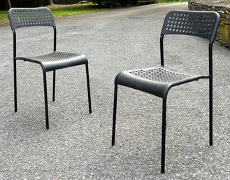 A Pair Of Modern Molded Plastic Chairs On Metal Frames