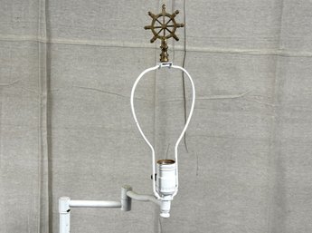 A White Metal Floor Lamp With A Brass Ship's Wheel Finial