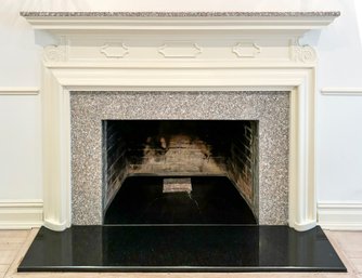 A Grand Fireplace With Granite Mantle Shelf, Hearthstone, And Tile Surround