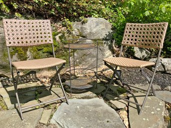 A Pair Of Woven Acrylic Folding Chairs And A Wrought Iron Side Table