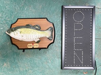 An 'Open' Sign And Mechanical Noisemaking Fish Mount