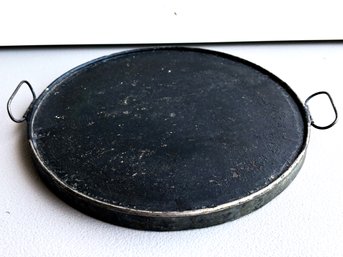 A Cast Iron Griddle Pan With Metal Trim