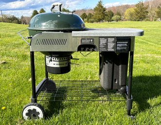 A Weber Charcoal Grill And Caddy