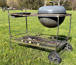 A Weber Charcoal Grill On Vintage Wrought Iron And Mesh Grill Stand