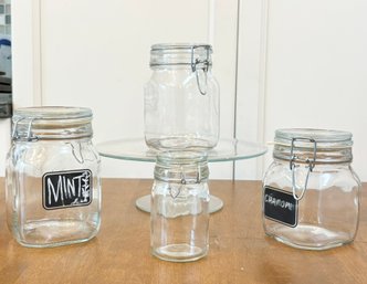 A Raised Glass Cake Plate And Kitchen Canisters