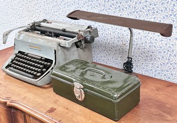 A Vintage Typewriter, Desk Lamp, And Tackle Box